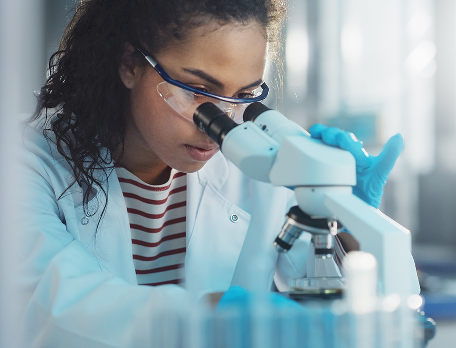 technician look at sample through microscope